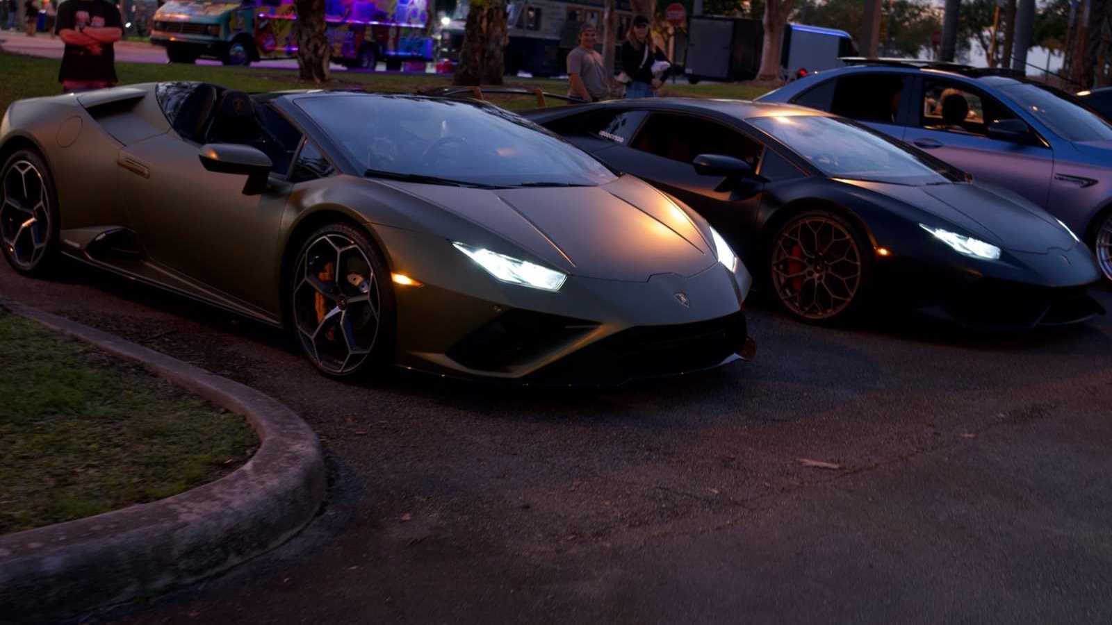 Sports cars lined up at a FastTrack car meet at sunset